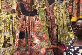 Douala le jeudi 4 mars 2021. Une vendeuse de robes de la Journée internationale de la femme au marché des Femmes présente un modèle. Photo: Moustapha Oumarou